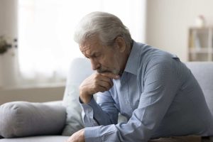 Sad lonely grey haired old man thinking on geriatric health problems, bored retirement at home, feeling sick, tired, suffering from depression, memory loss, mental disorder