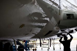 Aircraft maintenance technician checking airplane for safety in airport hanger
