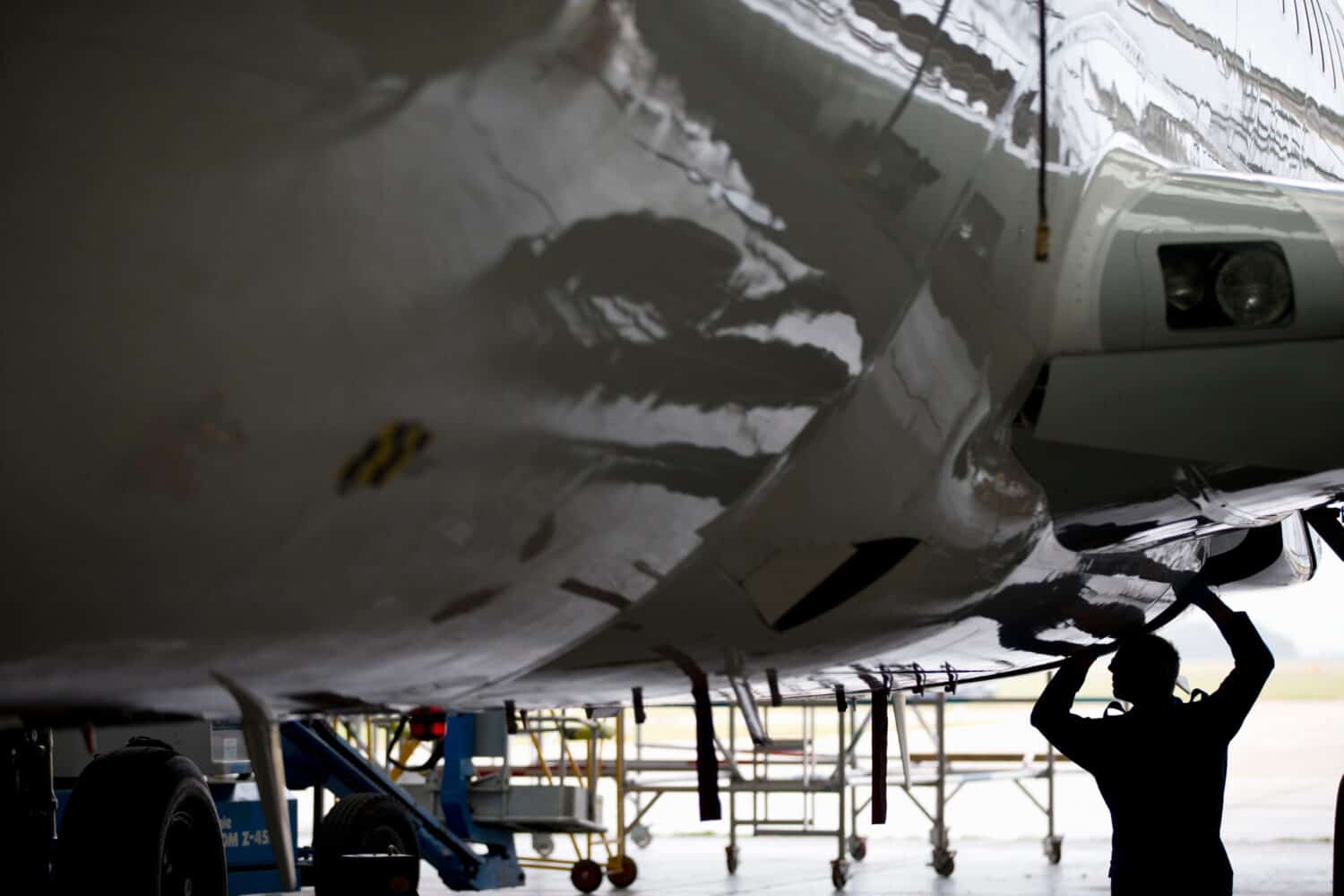 Aircraft maintenance technician checking airplane for safety in airport hanger