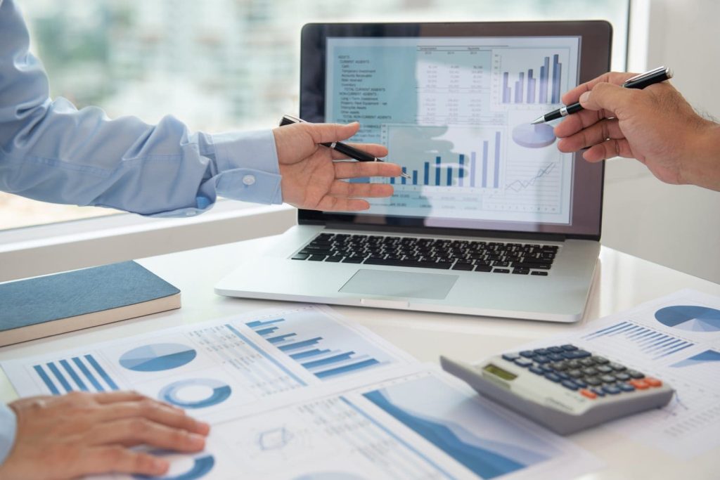 Financial analyst analysis business financial report on digital tablet during discussion at meeting of corporate showing the results of their successful teamwork.