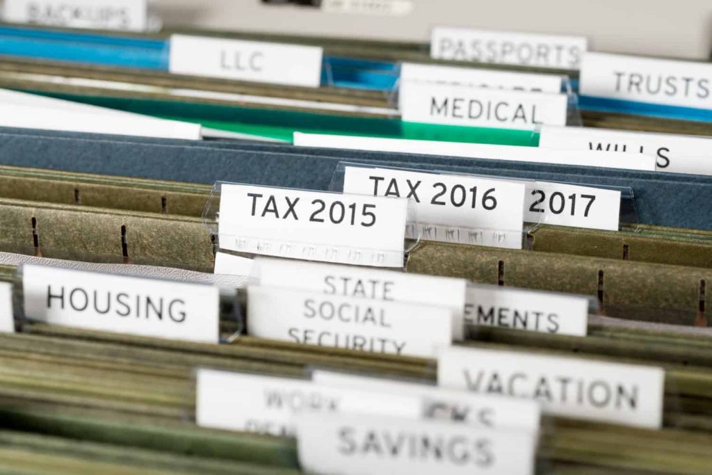 Close up of a well organized home filing system with tabs for each subject and focus on tax return papers