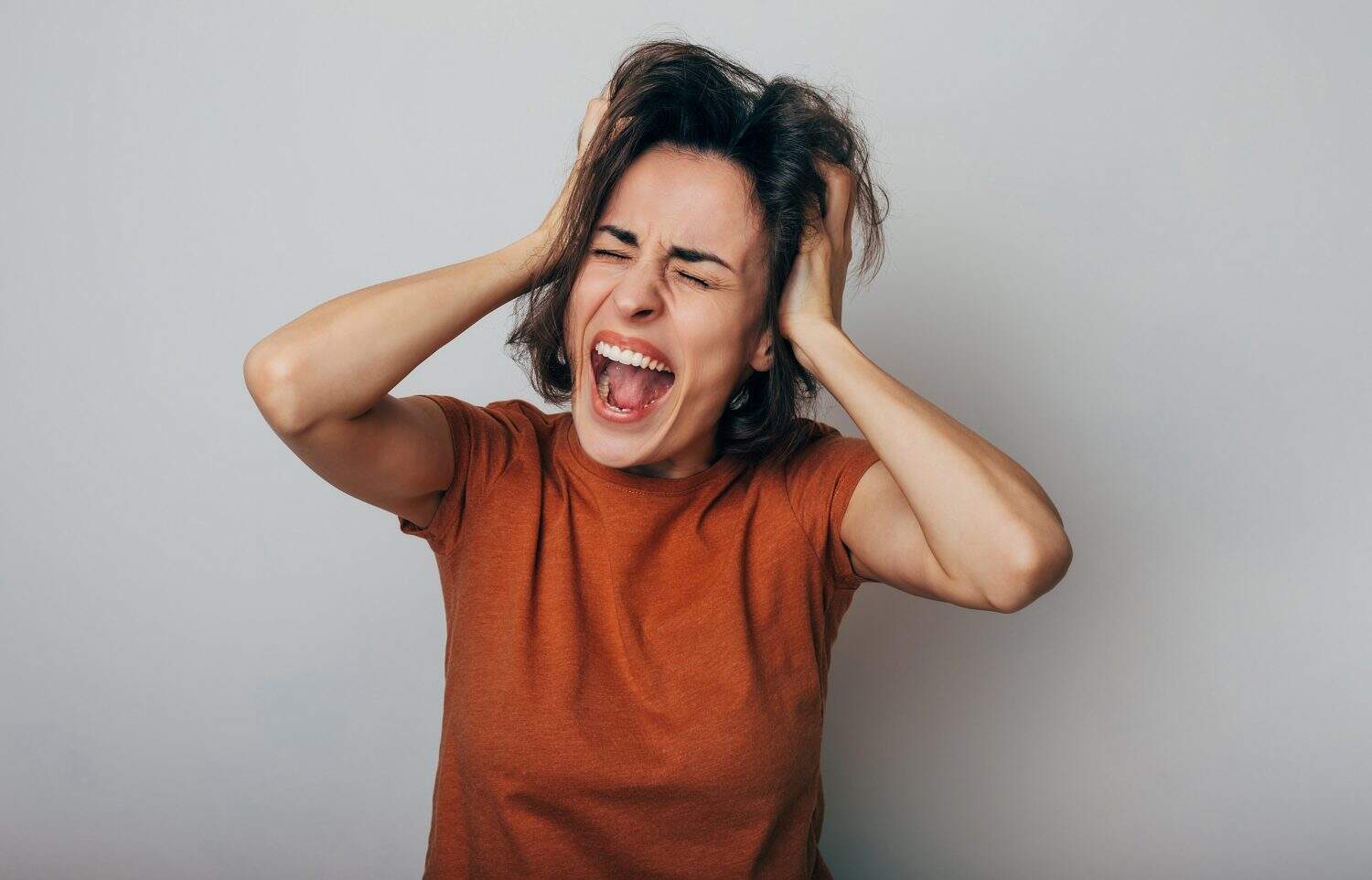 A frustrated woman reacts emotionally to upsetting news.