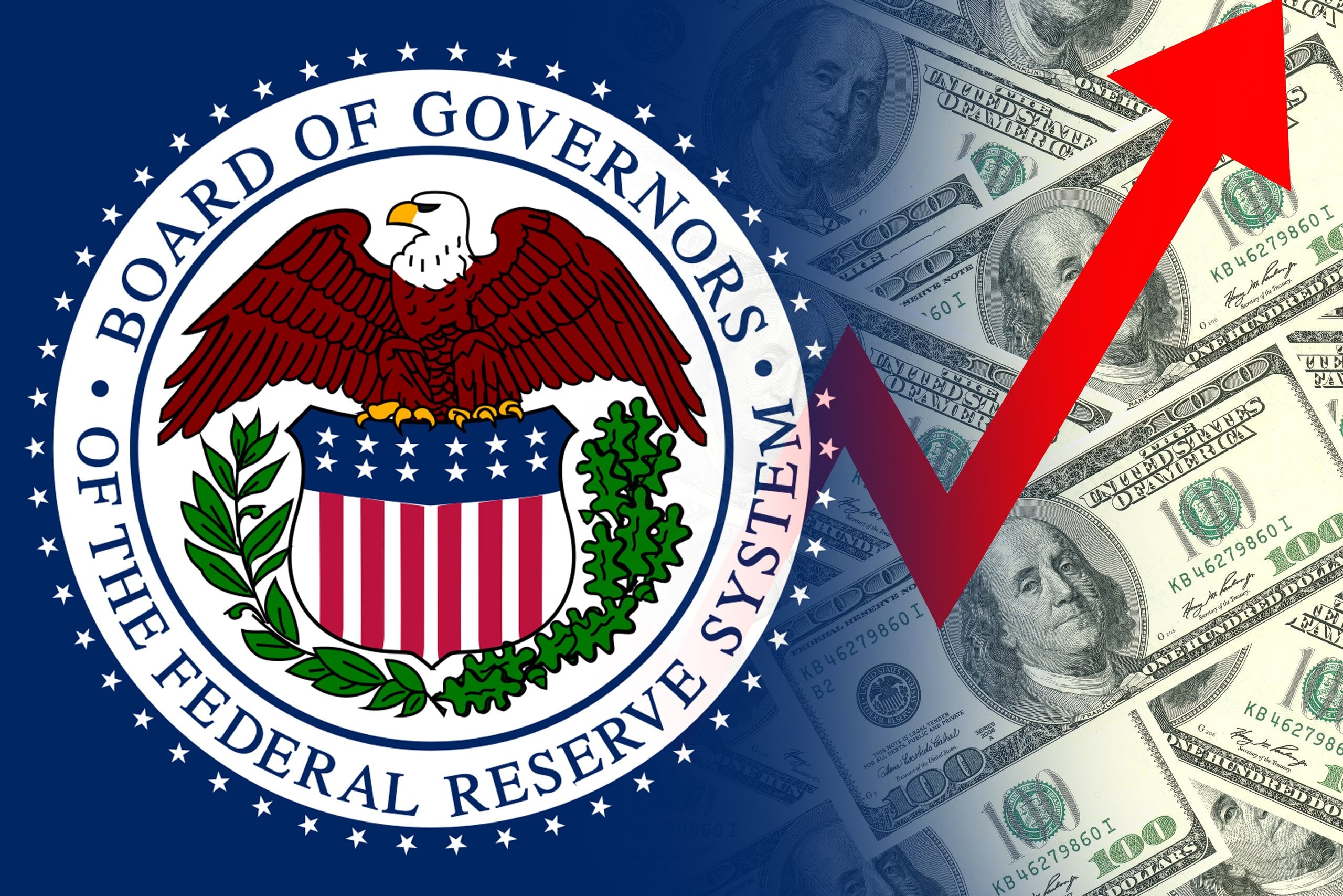 The official seal of the Board of Governors of the Federal Reserve System, colored red, white, blue, and gold, is displayed on a dark blue background. The seal partially overlays a bright background composed of scattered U.S. one hundred-dollar bills. A large, diagonal red arrow points from the lower left corner towards the upper right corner across the image.