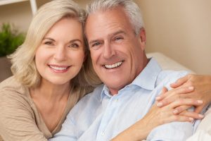 Happy senior man and woman couple together at home smiling, healthy and happy