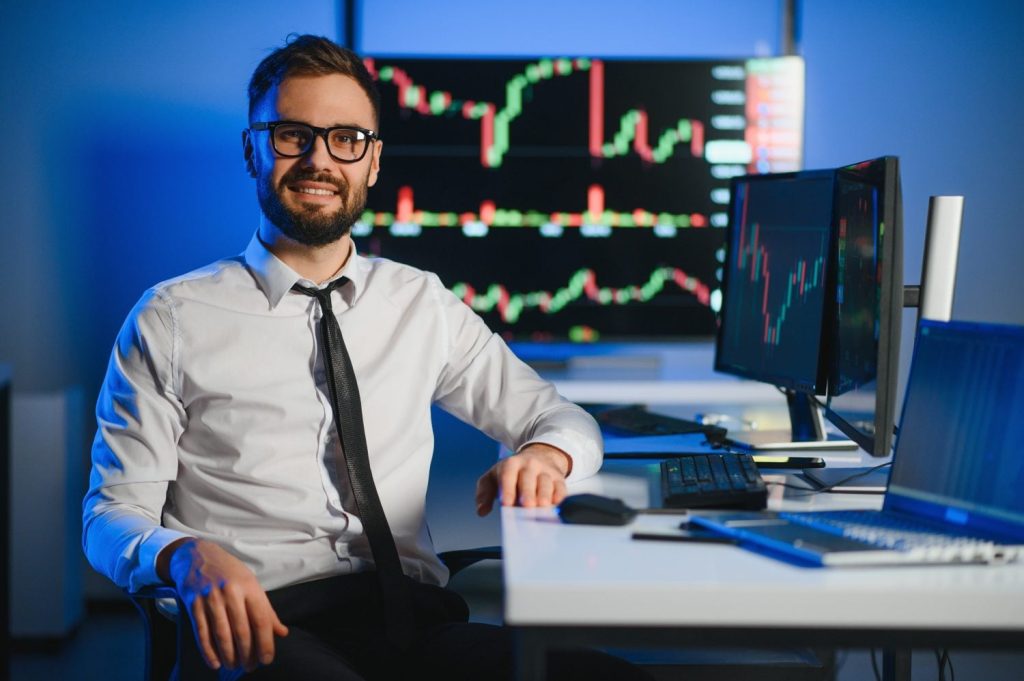 Crypto trader investor analyst looking at computer screen analyzing financial graph data on pc monitor, thinking of online stock exchange market trading investment global risks, over shoulder view.