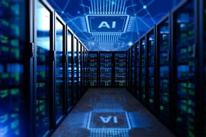 A long, dark data center corridor is illuminated by blue and green lights emanating from server racks lining both sides. A large, luminous blue graphic of a microchip with the letters 'AI' is projected onto the ceiling and its inverted reflection appears on the glossy floor. The background features a blurred blue network circuit pattern, reinforcing the high-tech, digital theme.