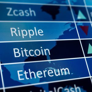 A close-up photograph of a blue digital screen showing a list of cryptocurrency names: Zcash, Ripple, Bitcoin, and Ethereum, in white text. A faint world map overlay and white grid lines are visible in the background. To the right of the names, green upward-pointing and red downward-pointing triangular arrows indicate market trends.