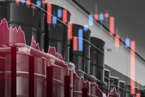 A grayscale image features rows of black industrial oil barrels, some stacked on wooden pallets, against a light-colored industrial building. Transparent red and blue candlestick charts, a jagged pink line graph, and solid red vertical bars are overlaid, all indicative of a market downturn.