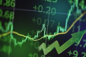 A digital screen displaying financial market data predominantly in shades of green against a dark background. The image features an ascending green candlestick chart, an overlaid yellow line graph also trending upwards, and large green numerical figures such as "+0.20" and "+0.07." A significant 3D green arrow points diagonally upwards to the right, symbolizing growth and positive market movement.