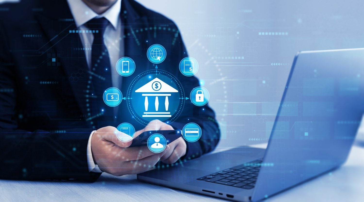 A person in a dark suit holds a smartphone, engaging with a glowing blue digital overlay representing banking and financial technology. The central icon is a bank building with a dollar sign, surrounded by interconnected icons for mobile banking, global access, financial documents, security, credit cards, user profiles, and digital receipts. A laptop is visible on the right, and the background features abstract blue digital patterns, conveying a futuristic and interconnected financial system.